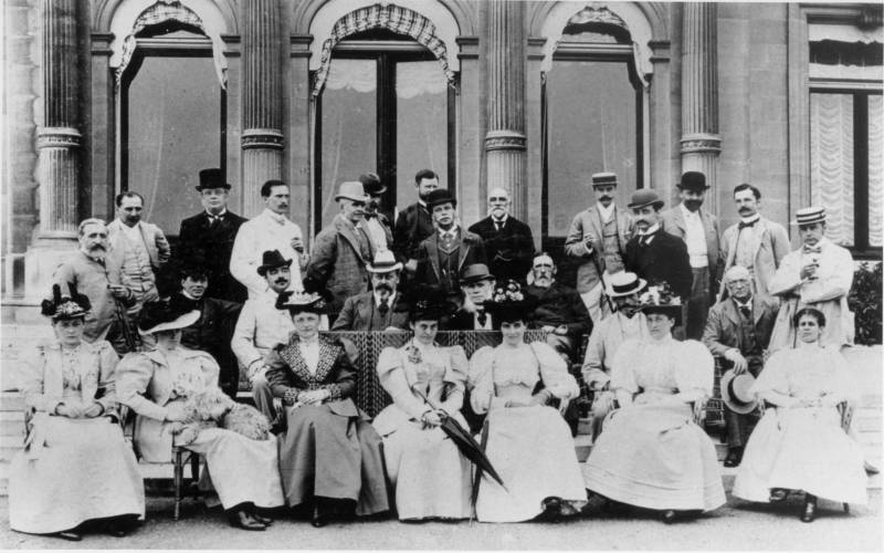 Houseparty guests seated outside the manor
