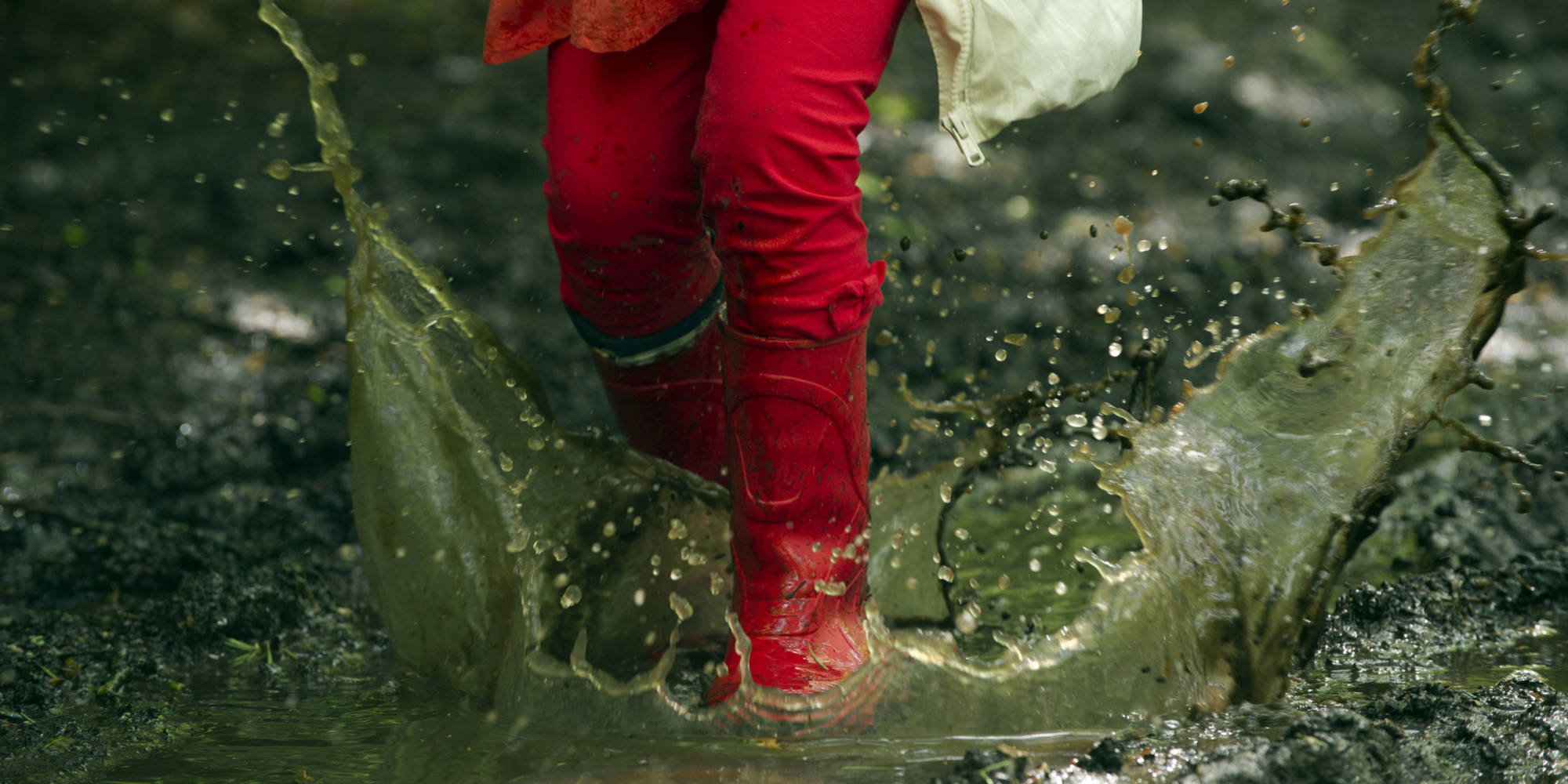 young girl splasing in a puddle