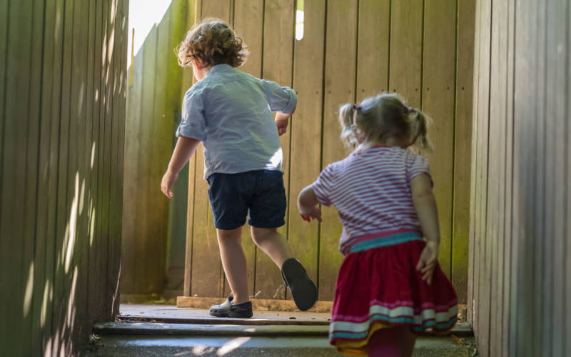 two young children enjoying the woodland playground