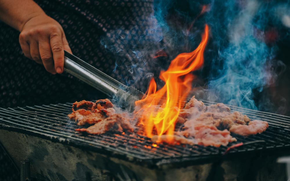 Sausages and beefburgers being cooked on a barbecue